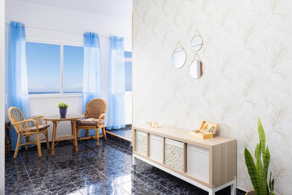 een eetkamer met een tafel en stoelen en een muur bij Apartamento Horizonte Azul in Punta del Hidalgo