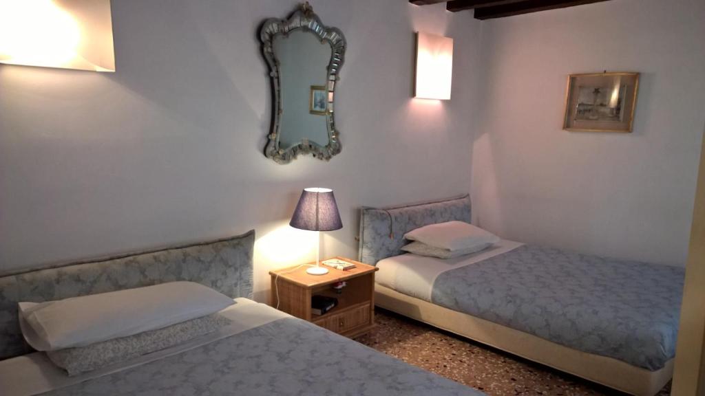 威尼斯的住宿－DoMarie，客房设有两张床和一张带镜子的桌子