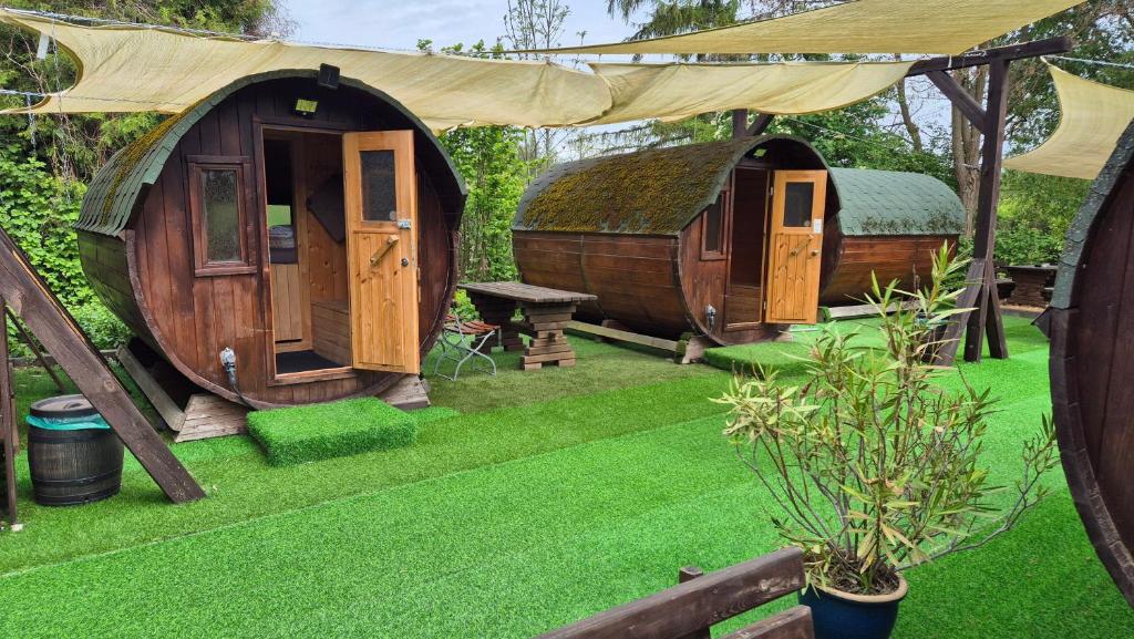 een groep hutten in een tuin met gras bij Mini Hotel Übernachten Im Gurkenfass in Lübbenau