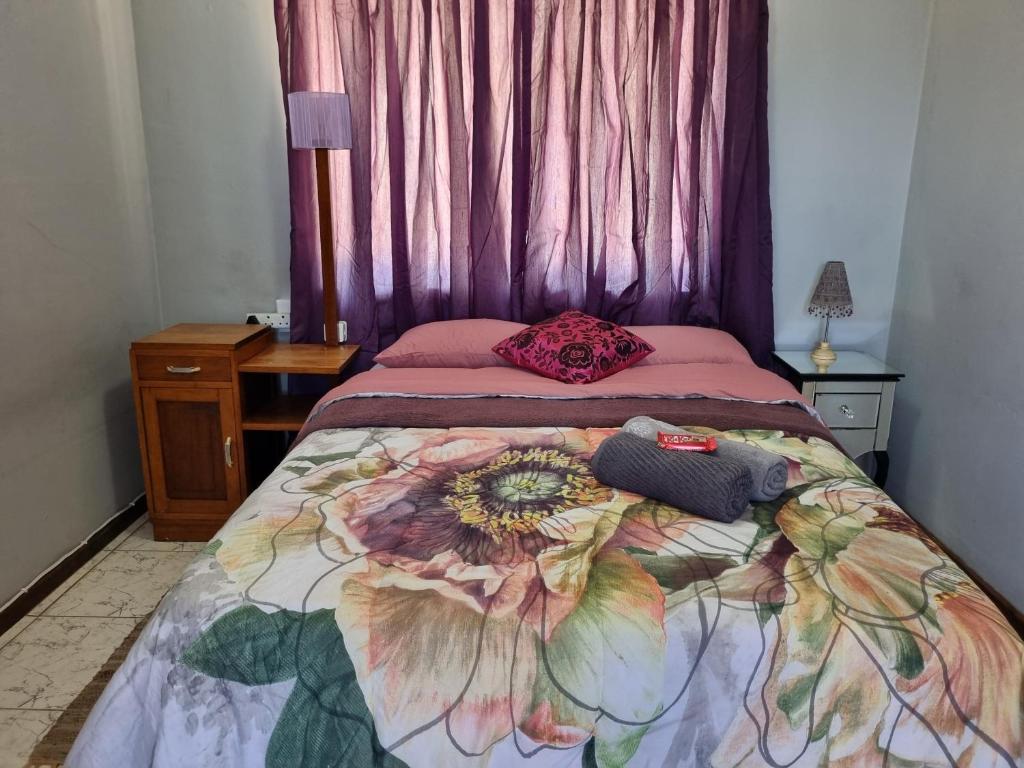 En eller flere senge i et værelse på Ukhozi Petal Pods