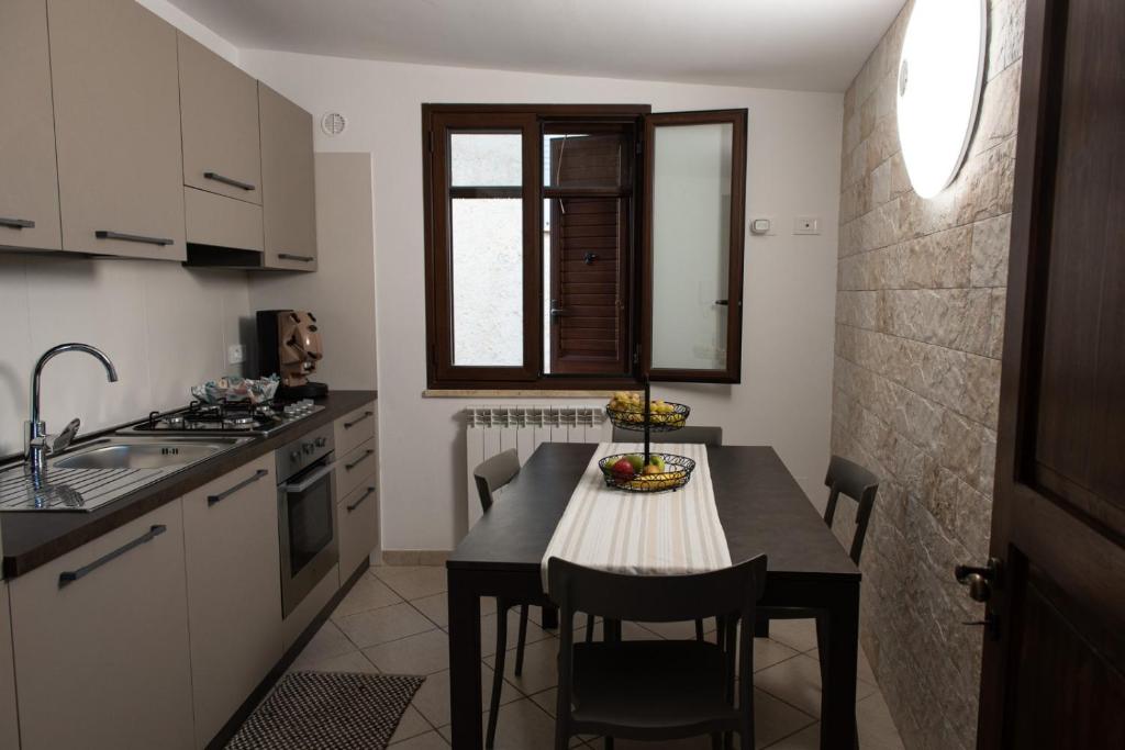 a small kitchen with a table and chairs in it at La Casetta di Josh in Marsala