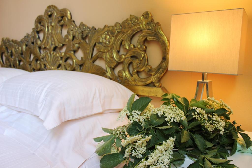 a bedroom with a bed with a mirror and flowers at La Trigola in Santo Stefano di Magra