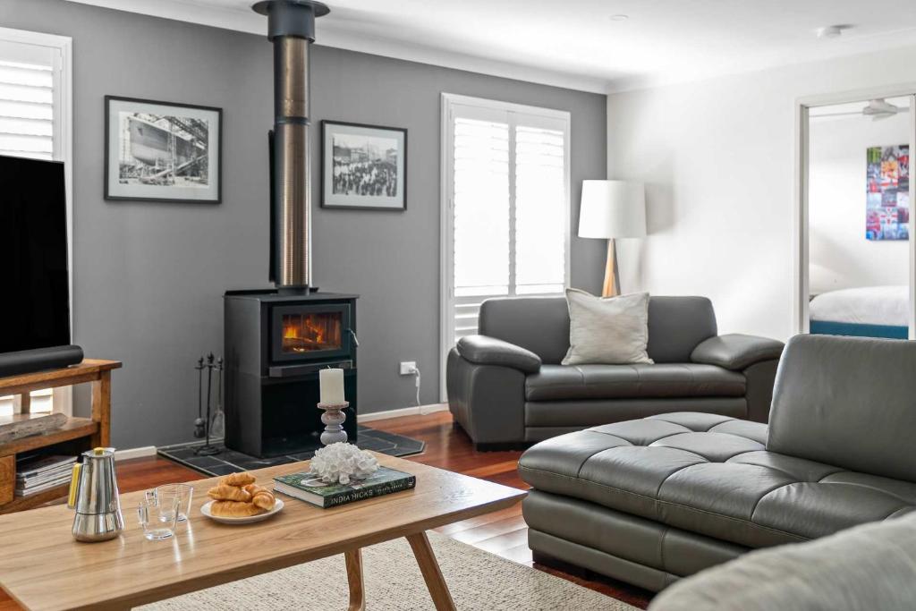 een woonkamer met een bank en een open haard bij Bliss at Jervis Bay - pet-friendly Vincentia home in Vincentia