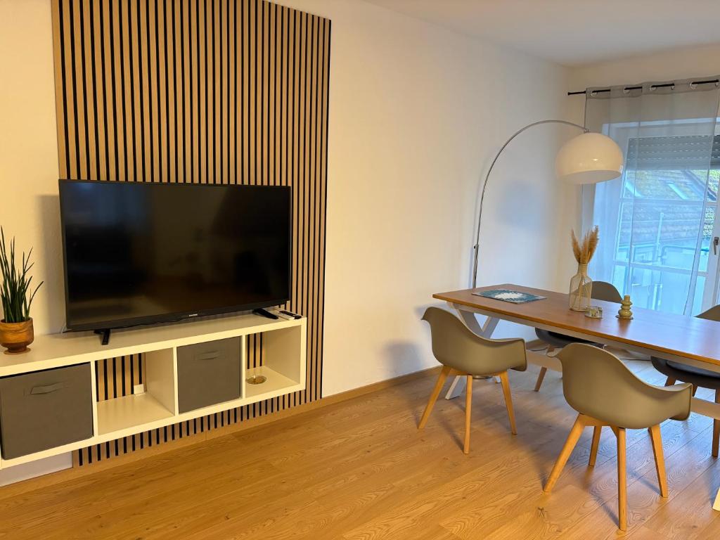 ein Wohnzimmer mit Tisch und Fernseher in der Unterkunft Großzügiges Design-Loft in Aulendorf in Niederdorla