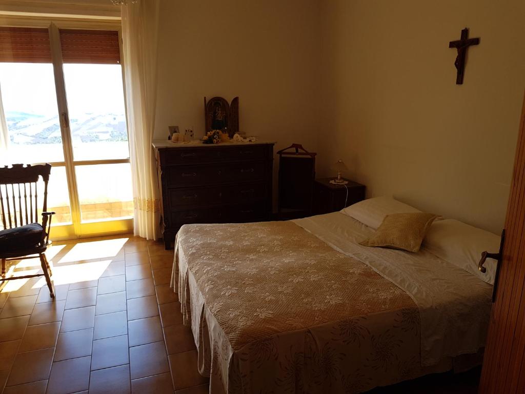 una camera con un letto e una croce sul muro di Clementina B&B a Brittoli