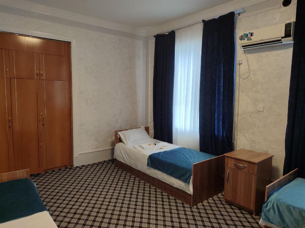 a small bedroom with a bed and a window at ASR HOSTEl in Andizhan