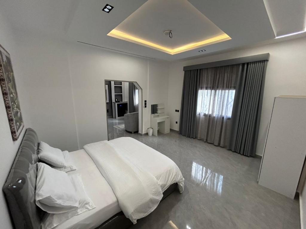 a white bedroom with a large bed with white sheets at قمرة قباء Quba moon1 in Medina