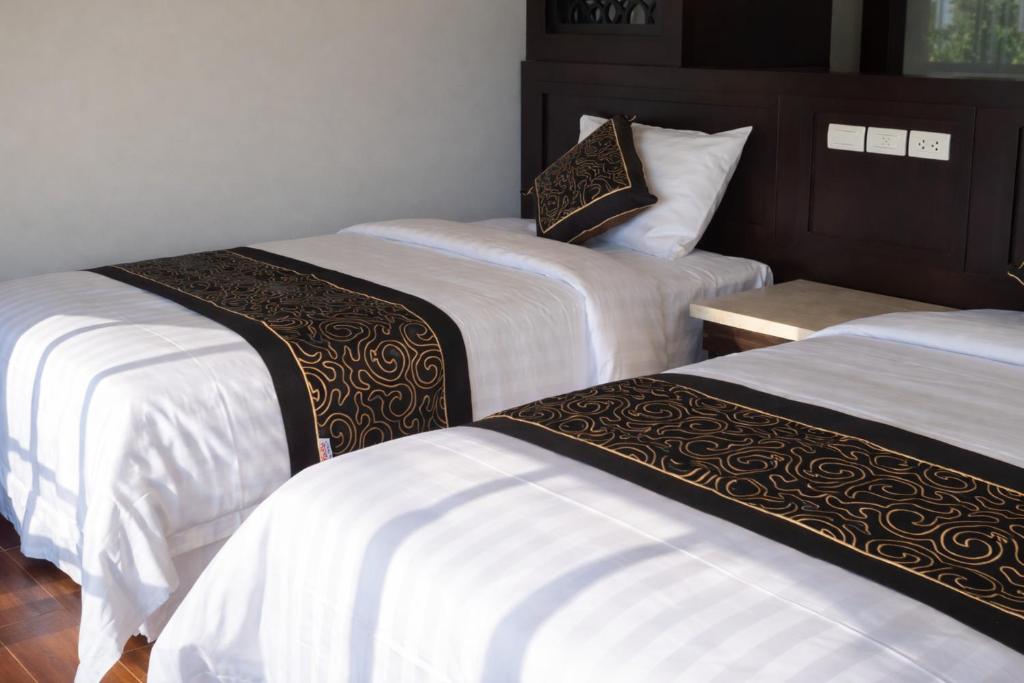 eine Gruppe von 3 Betten in einem Zimmer in der Unterkunft Hải Long Motel Phú Thọ in Phú Thọ