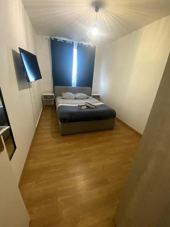 een kleine slaapkamer met een bed in een kamer bij Le Florimorizon in Le Havre