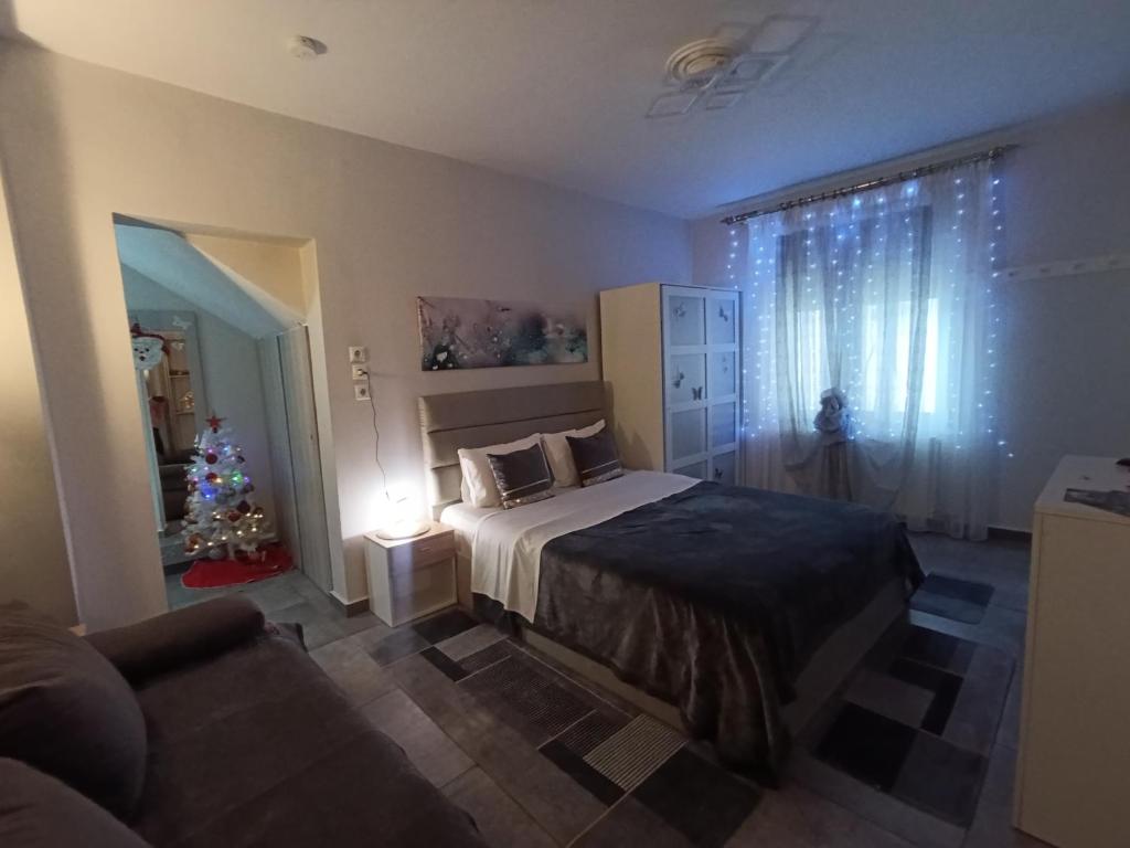 a bedroom with a christmas tree and a bed at Studio Santa Monica in Tríkala