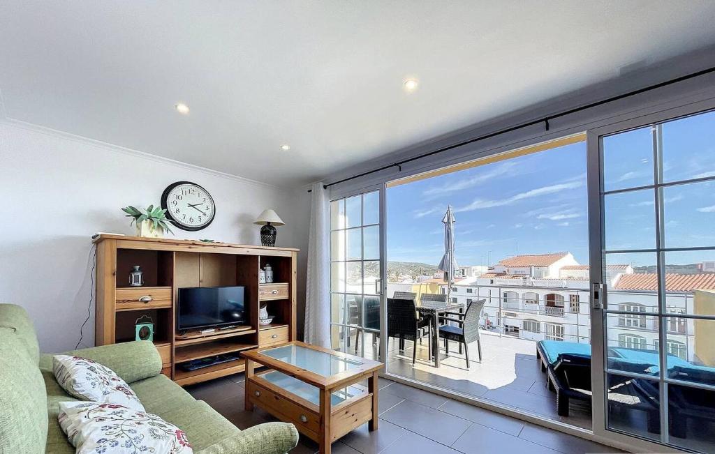 a living room with a couch and a large window at Dúplex Fornells Carme 3 in Fornells