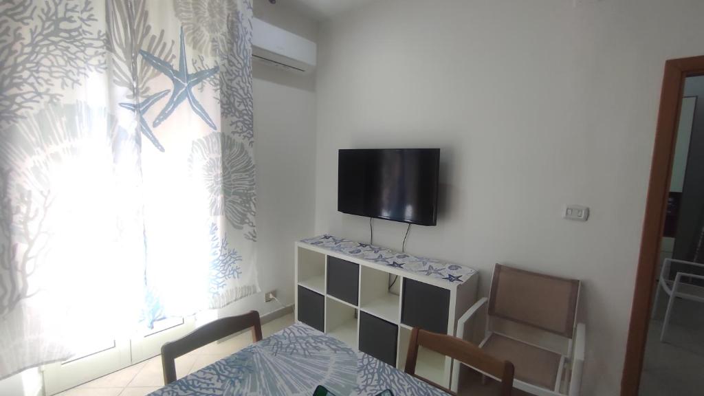 a room with a table and a tv on the wall at Casa del Ferroviere in Letojanni