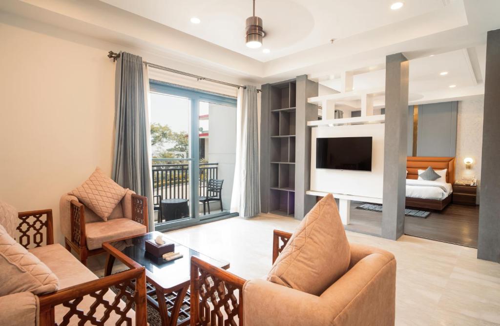 达兰萨拉Dhauladhar Heights Resort的客厅里有一张沙发和一台电视