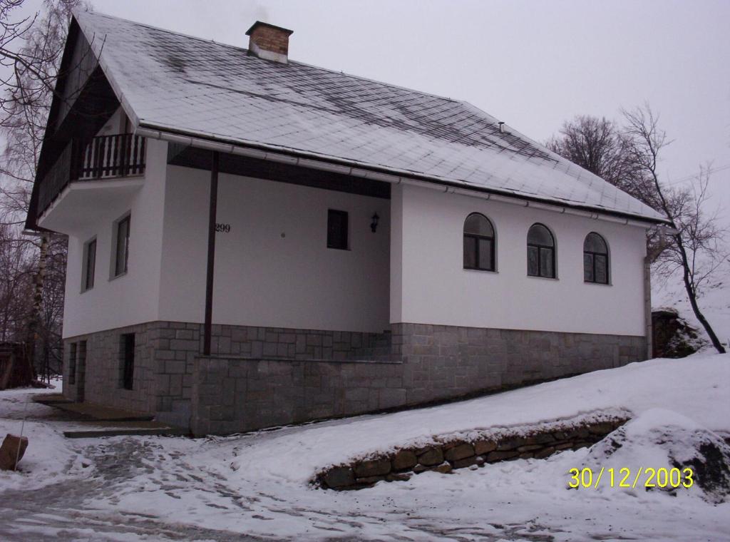 una iglesia blanca con nieve en el suelo en Ubytování v Jeseníkách - Bělá pod Pradědem en Adolfovice