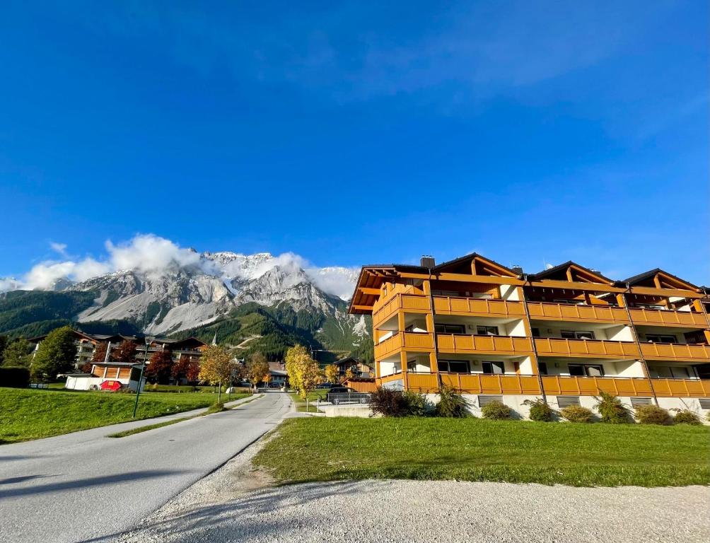 a building on the side of a road with a mountain at Ramsaublick in Ramsau am Dachstein