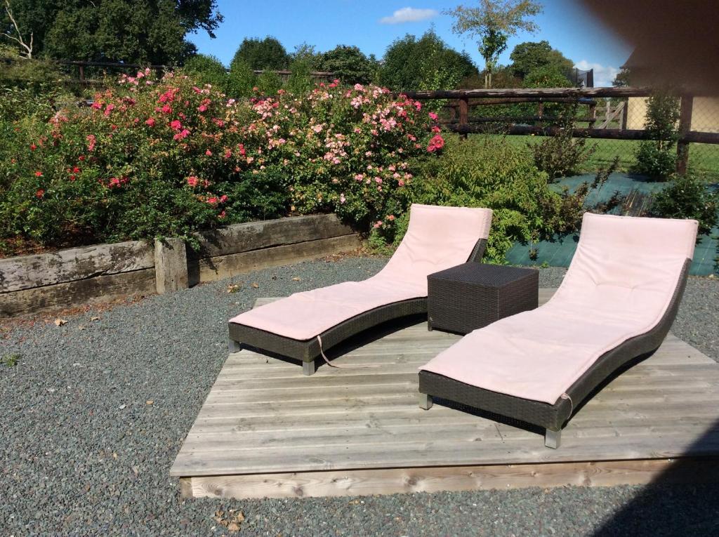 a couple of chairs sitting on a wooden deck at Gîte De L&#39;Etot Fossey in Marchésieux