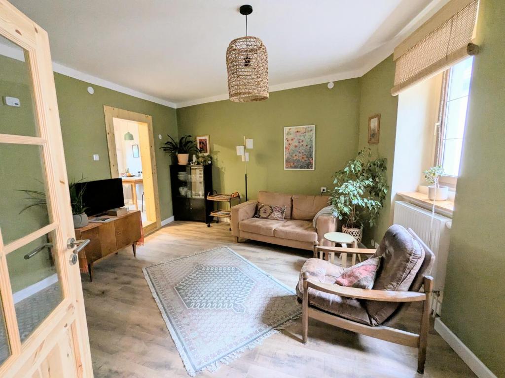 een woonkamer met groene muren en een bank bij Ferienhaus Glockenklang in Sangerhausen