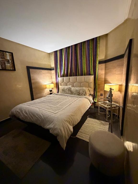 a bedroom with a large bed and a chair at Welcome to your Stylish apartment in Oulad Akkou