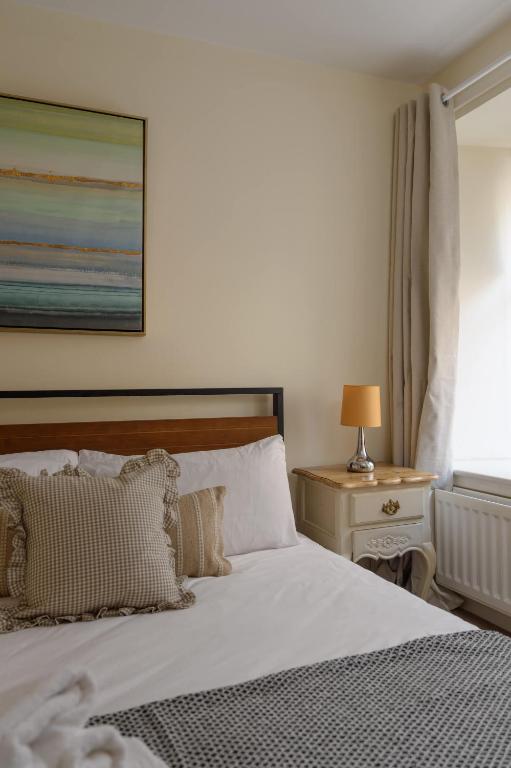 a bedroom with a bed and a table with a lamp at Cozy 3BR escape near Edinburgh centre in Edinburgh