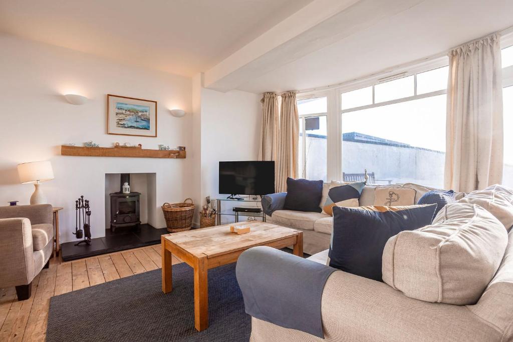 a living room with two couches and a tv at Shore Cottage - Lower Largo in Lower Largo