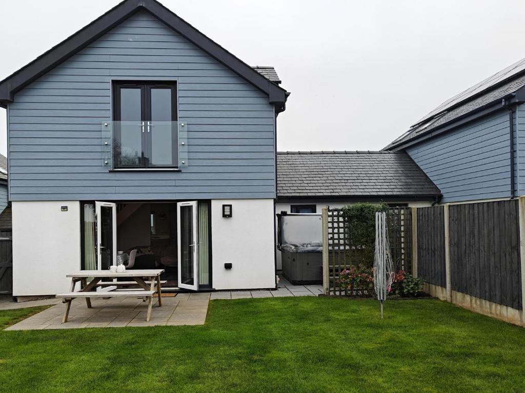 una casa con un tavolo da picnic in un cortile di 3 Bed in Brynteg oc-d33659 a Llanallgo