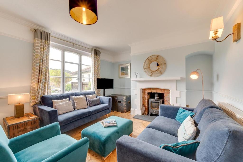 a living room with blue couches and a fireplace at 3 Bed in Beer oc-jb9wes in Beer