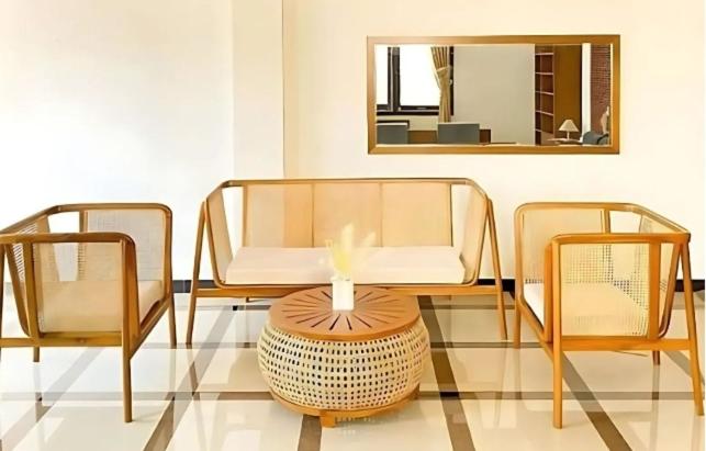 een kamer met 2 stoelen, een tafel en een spiegel bij Apartemen Bumi in Solo