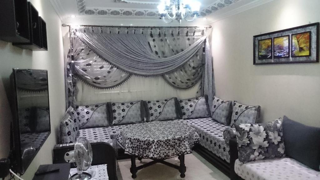 een woonkamer met een bank en een tafel bij Jawharat Tetouan in Souani