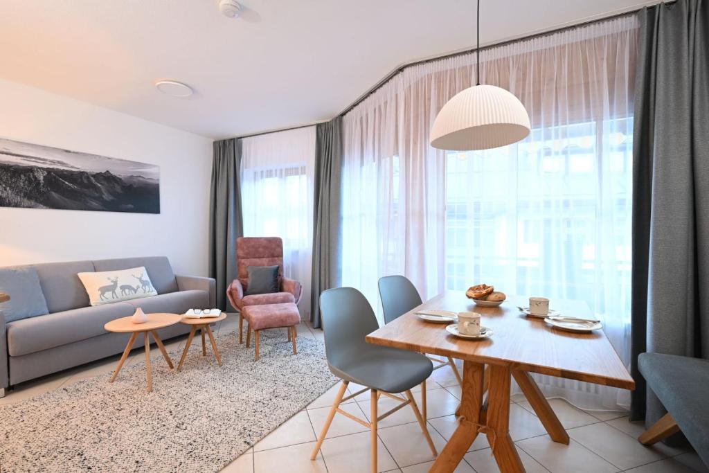 a living room with a couch and a table and chairs at Ferienwohnung Nau in Oberstdorf