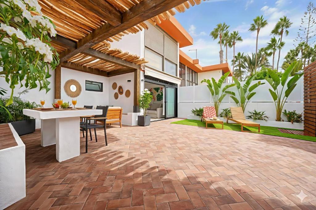 een buitenterras met een tafel en stoelen bij Royal Blue San Agustin in San Bartolomé