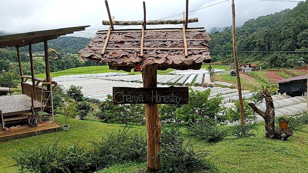 een teken op een paal voor een veld bij จรรยา โฮมเสตย์ in Chom Thong