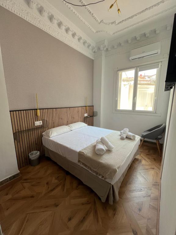 een slaapkamer met een bed met twee handdoeken erop bij B&B Valencia in Valencia