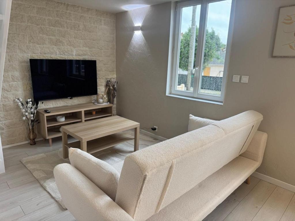 ein Wohnzimmer mit Sofa und Fernseher in der Unterkunft Perfect cocoon for a romantic stay in La Celle-sous-Gouzon
