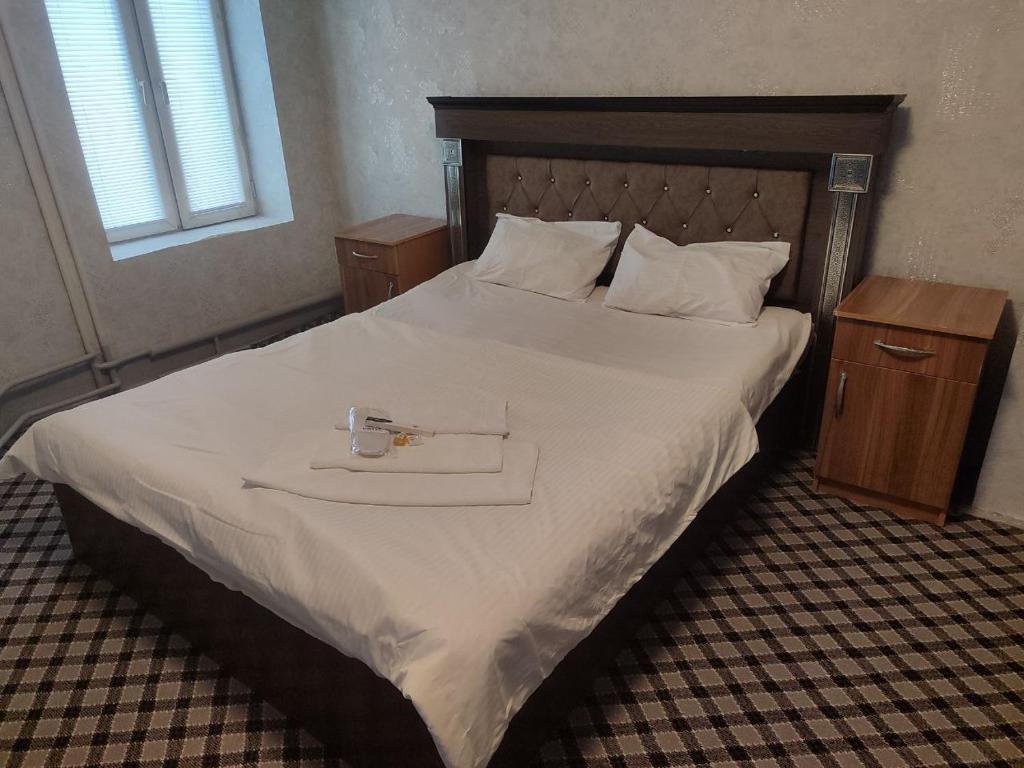 a bedroom with a bed with a tray on it at ASR HOSTEl in Andizhan
