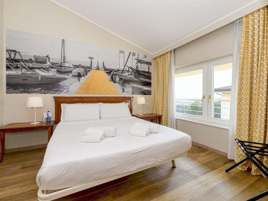 B&B Hotel Affi - Lago di Garda في آفي: غرفة نوم بسرير كبير ونافذة كبيرة