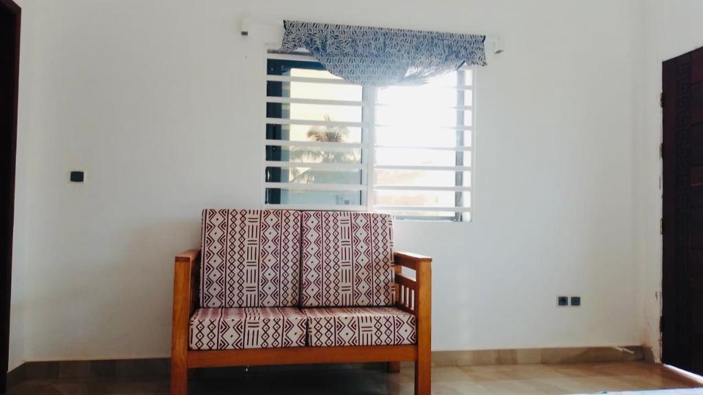 ein Stuhl in einem Raum mit einem Fenster in der Unterkunft Cozy studio I with AC and fan in Akassato