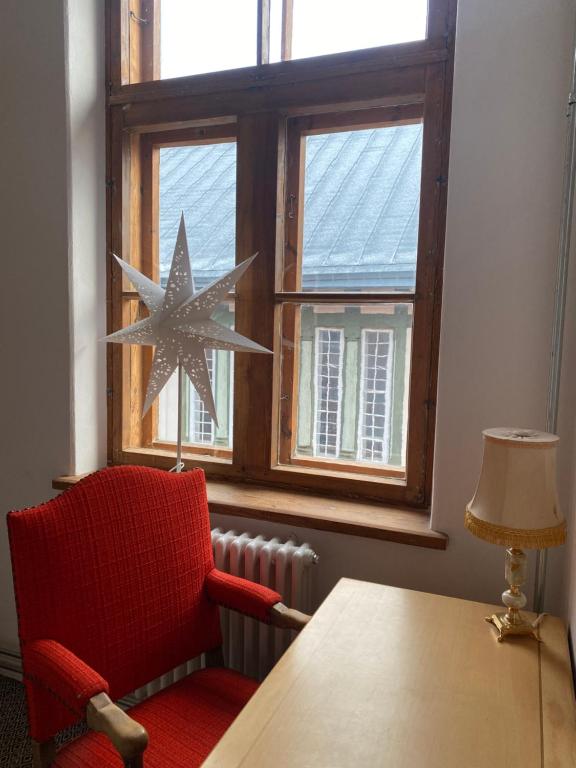 Zimmer mit einem Tisch, einem roten Stuhl und einem Fenster in der Unterkunft SecondHomeViljandi Apartment in Viljandi