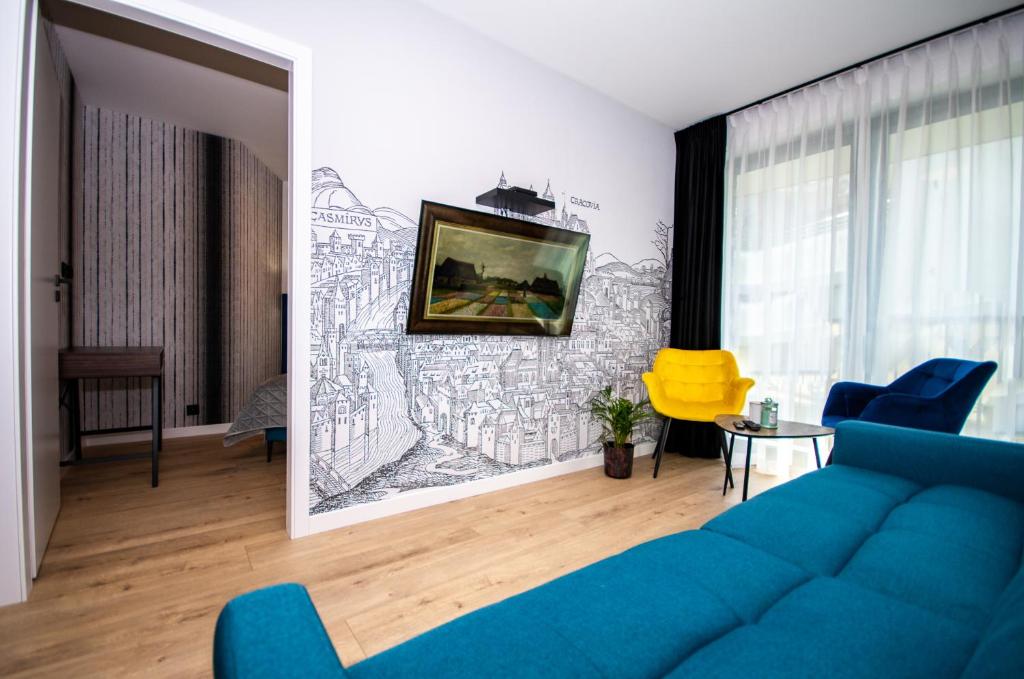 a living room with a blue couch and a drawing on the wall at InPoint Apartments G15 near Old Town & Kazimierz District & Optional Paid Parking in Kraków