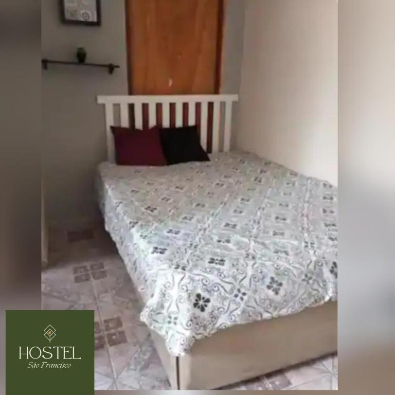 een slaapkamer met een bed met een wit dekbed bij Hostel São Francisco 1 in Votorantim