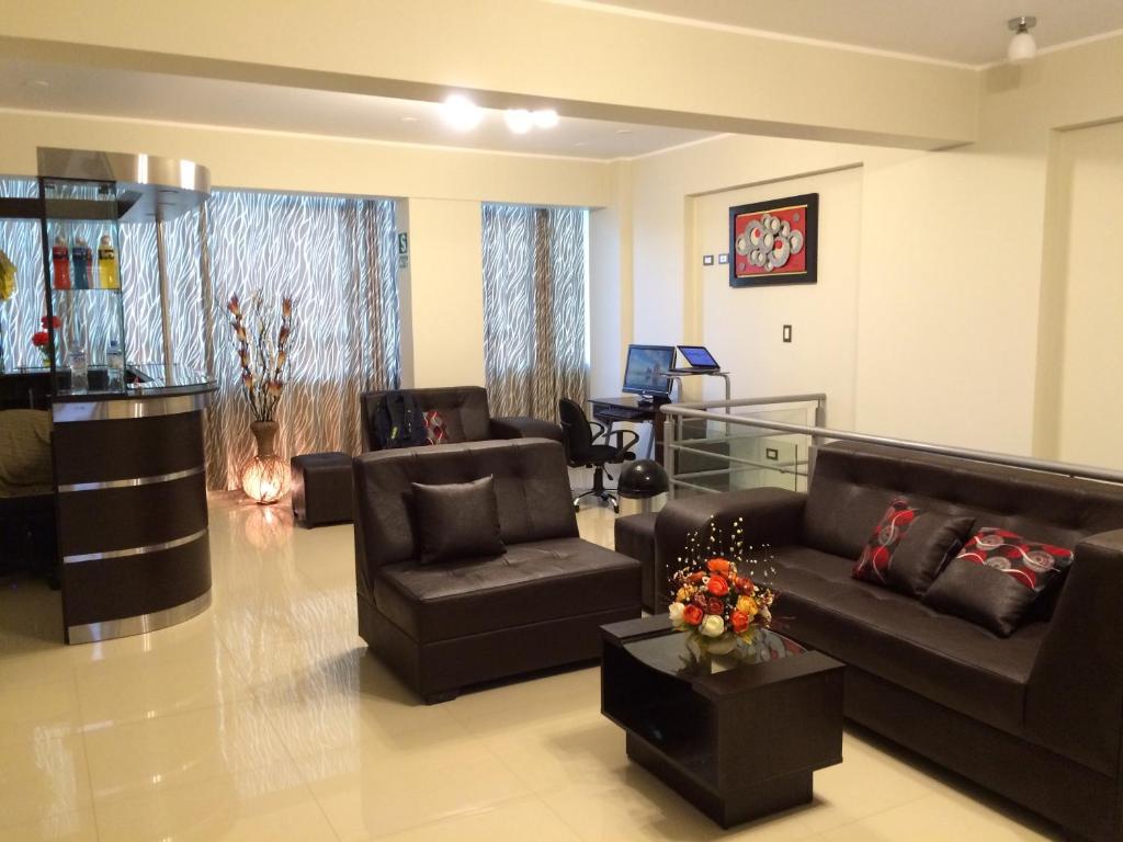 a living room with two couches and a table at Hostal Gold Star in Tacna
