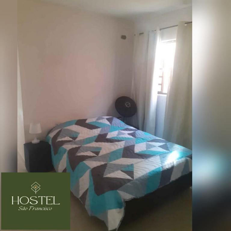 una camera da letto con un letto con un piumone colorato di Hostel São Francisco 4 a Votorantim