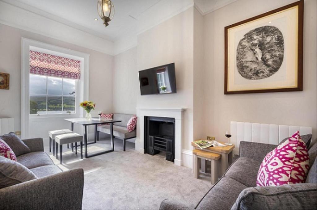 a living room with a couch and a table and a fireplace at 2 Bed in Soulby oc-a28927 in Pooley Bridge