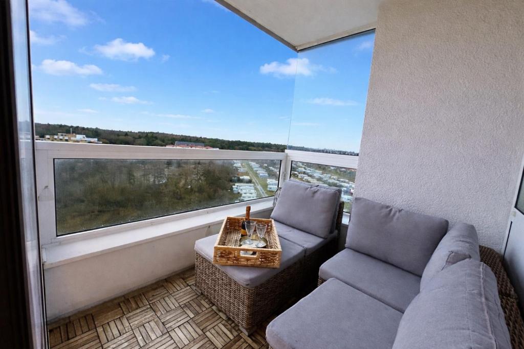 un soggiorno con un divano e un tavolo su un balcone di Frische Brise 704 a Sahlenburg