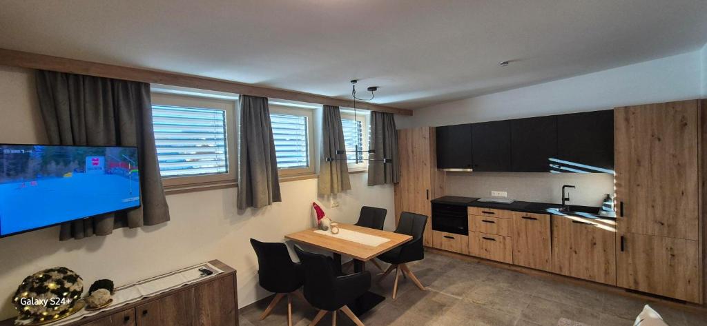 a kitchen with a table and a tv in a room at Appart Christophorus in Söll