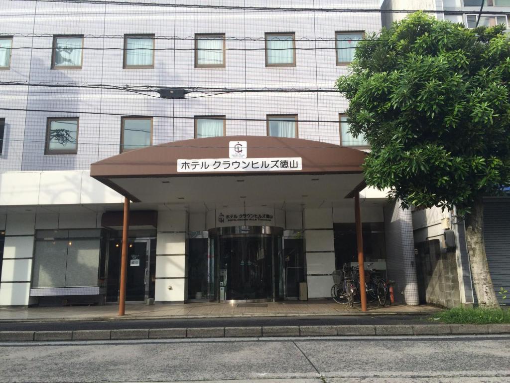 un edificio con un cartel en la parte delantera en Hotel Crown Hills Tokuyama, en Shunan
