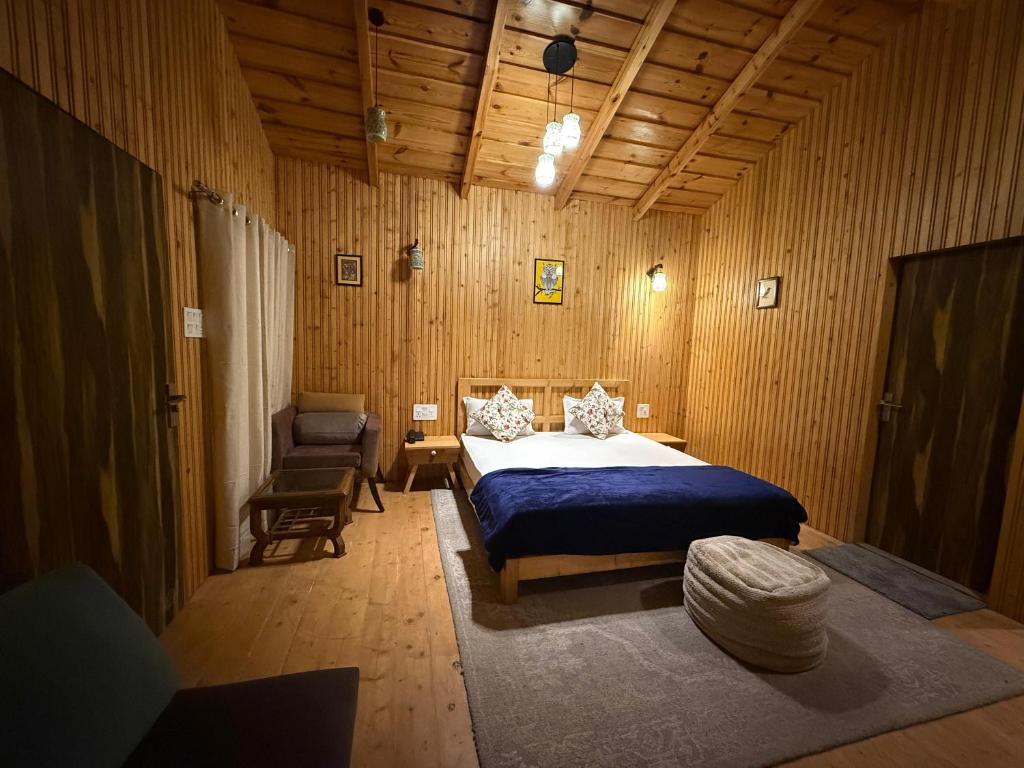 a bedroom with a bed and a chair at The Hilltop Hideaway in Mukteshwar