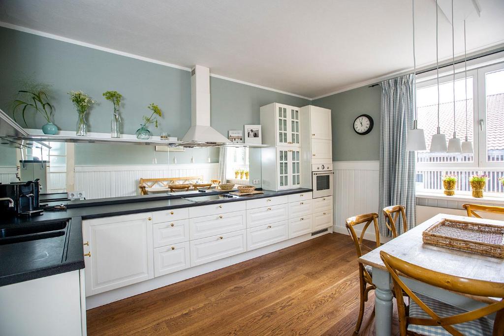 een grote keuken met witte kasten en een tafel bij Strömbergs Gunnar in Oberstaufen