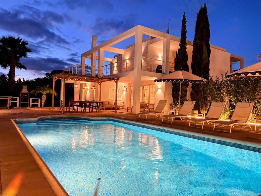 a villa with a swimming pool in front of a house at Villa in Playa den Bossa, 5 min SupermarketBBQ in Sant Jordi