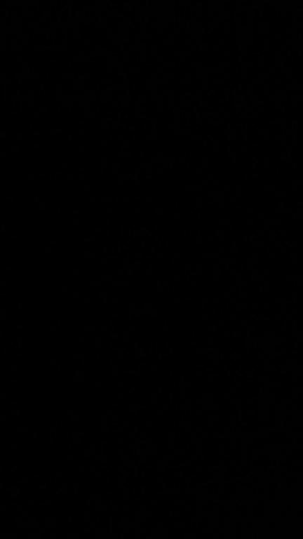 a dark room with a black background with a clock at Urban Nest in Gjakove