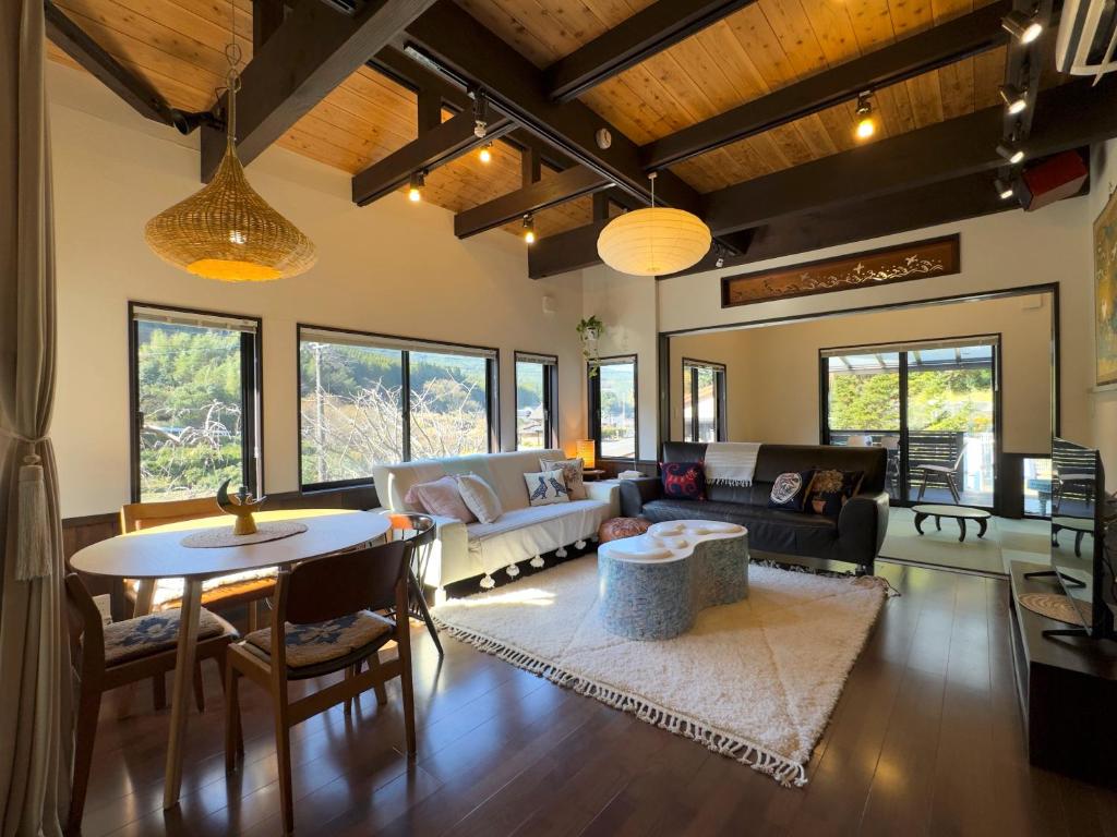 een woonkamer met een bank en een tafel bij IMARI HOUSE shachihoko イマリハウス しゃちほこ in Imari